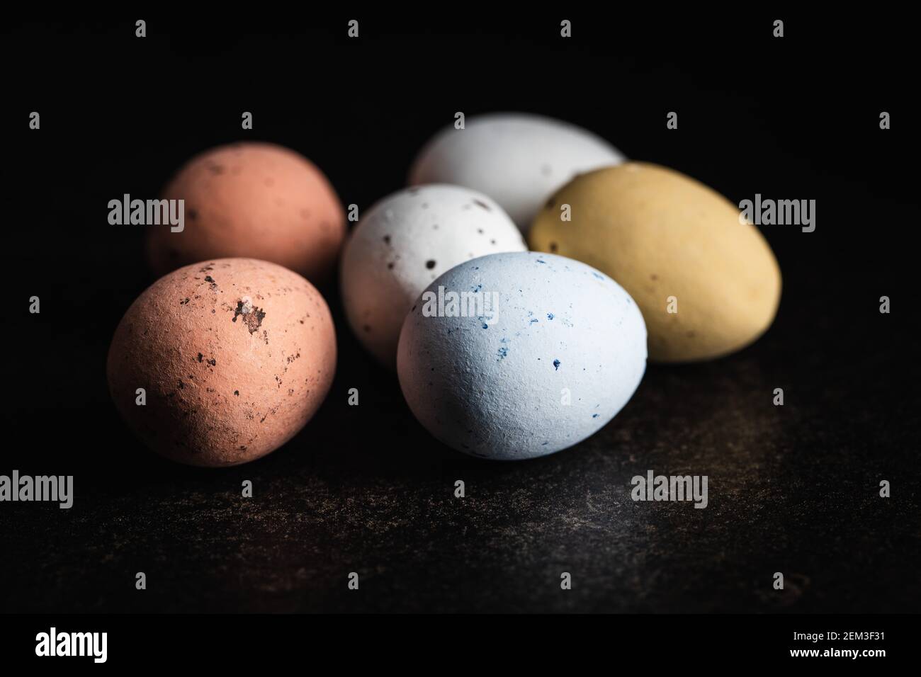 Colorful chocolate easter eggs. Sweet candy eggs on a black table. Stock Photo
