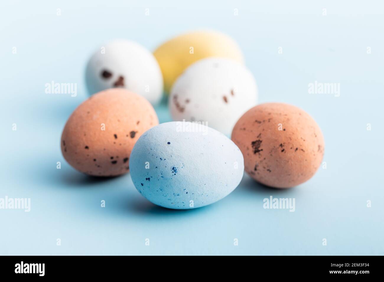 Colorful chocolate easter eggs. Sweet candy eggs on a blue background. Stock Photo