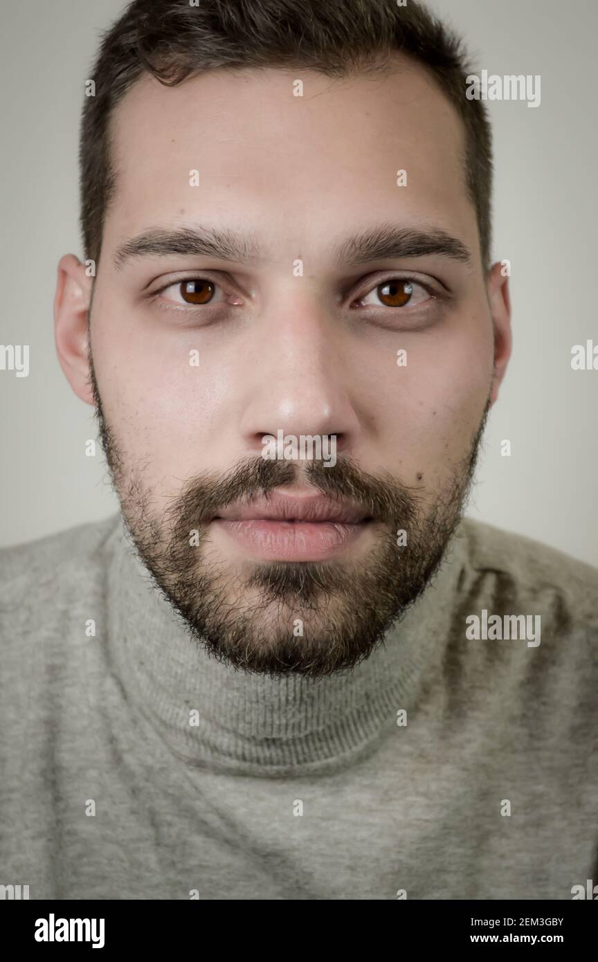 Portrait of a young brown-haired man with a short beard and a gray ...