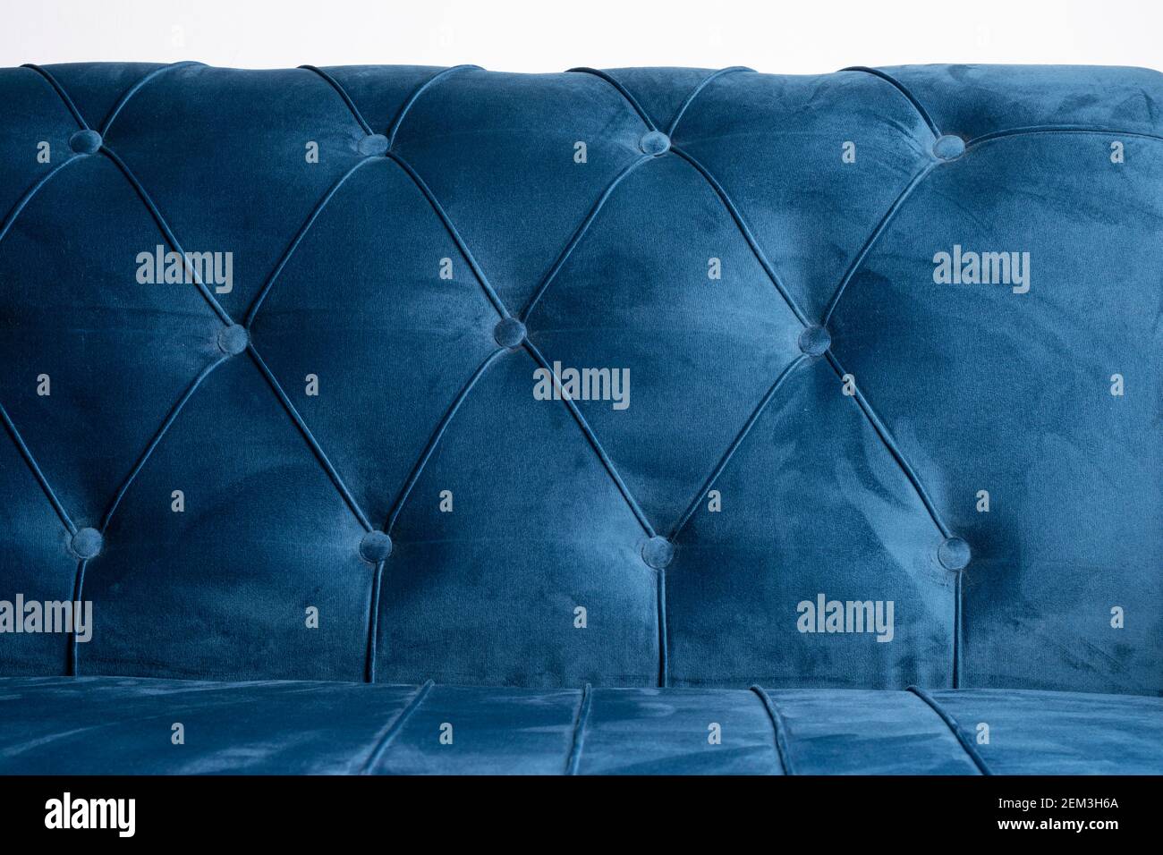 Blue velvet couch background texture with sunken buttons, Close up