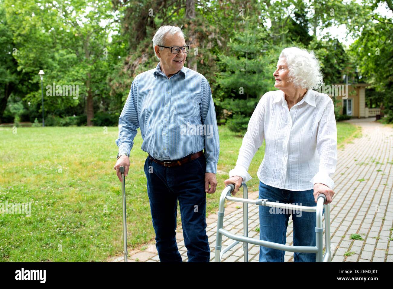Elder people using walking cane and a walker for a gentle stroll in the