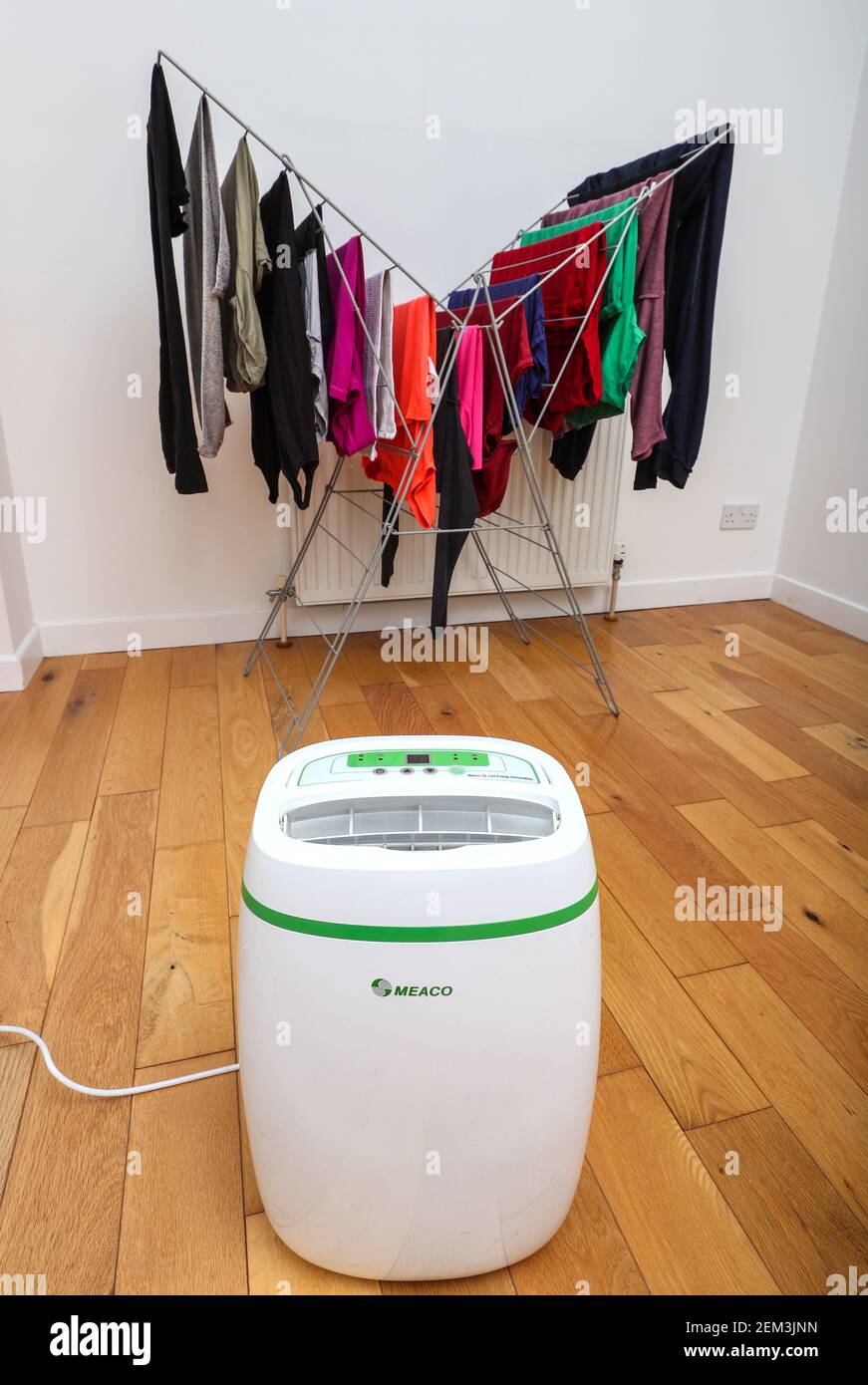 Dehumidifier drying clothes on an airer indoors Stock Photo