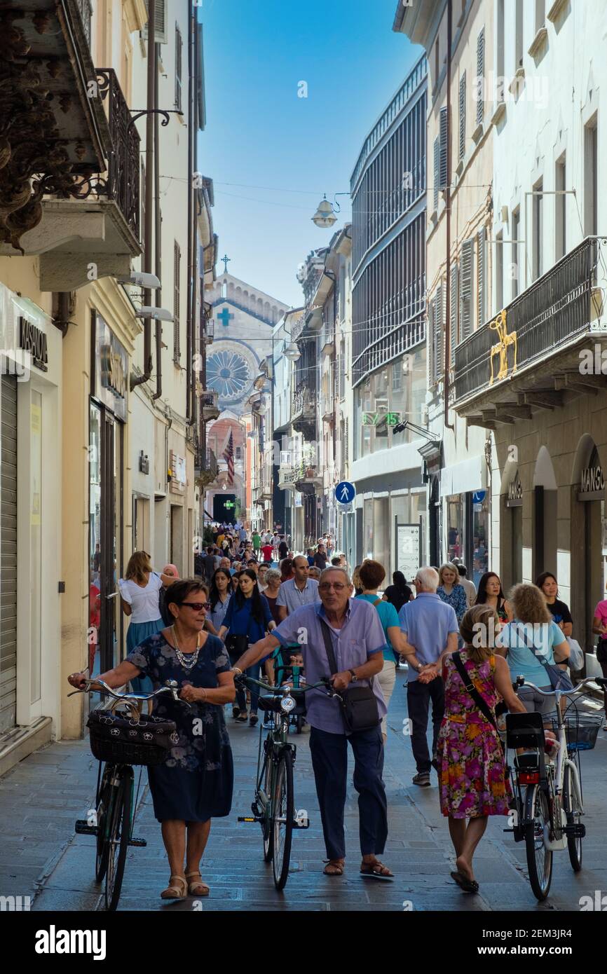 People relaxed on the street towards Cavalli Square and Piacenza Cathedral ( Duomo di Piacenza ) in sunny Piacenza, Emilia Romagna, Italy Stock Photo