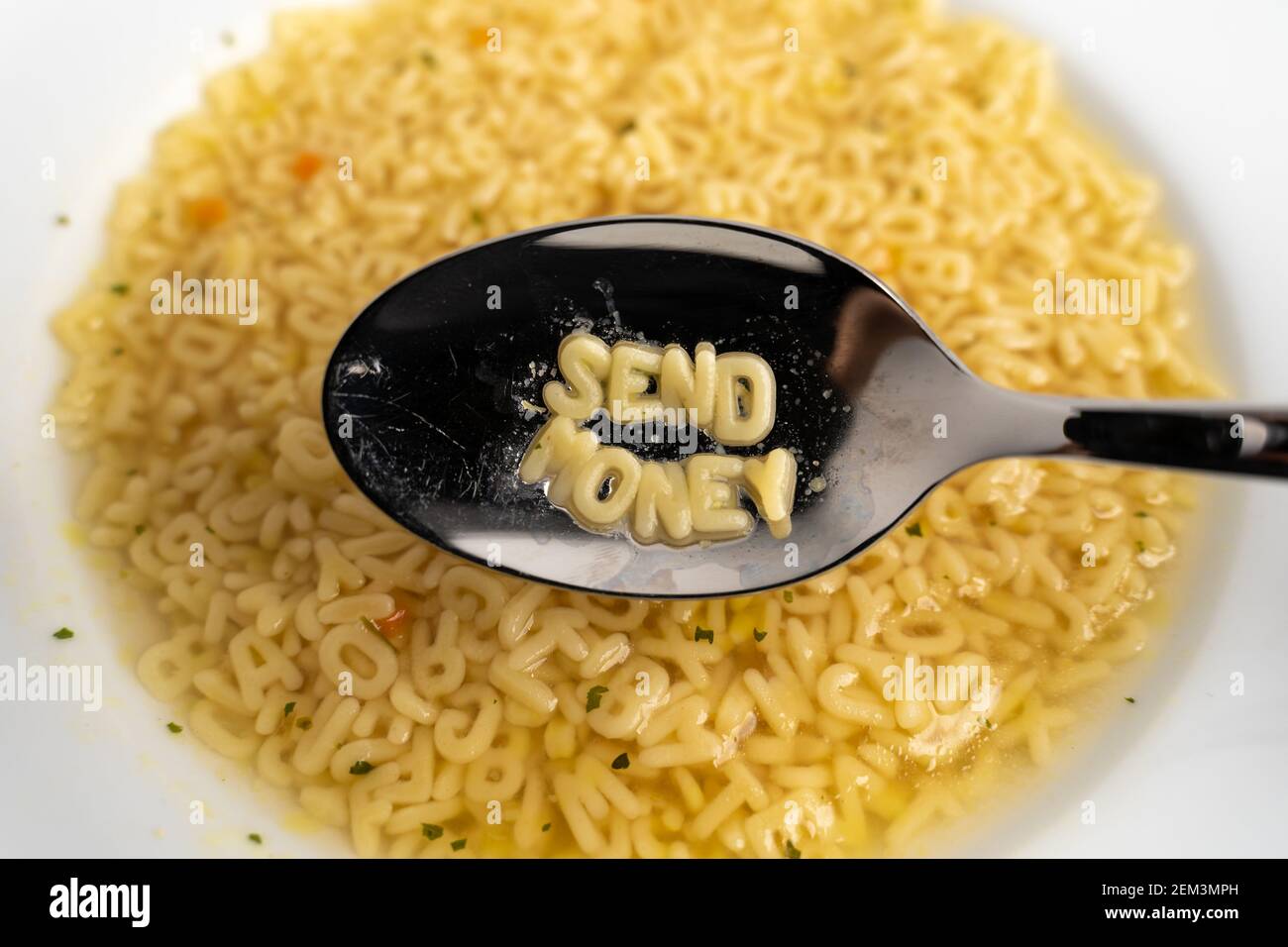 Alphabet soup letters with Send Money on the spoon, instant easy fast food because of poverty Stock Photo