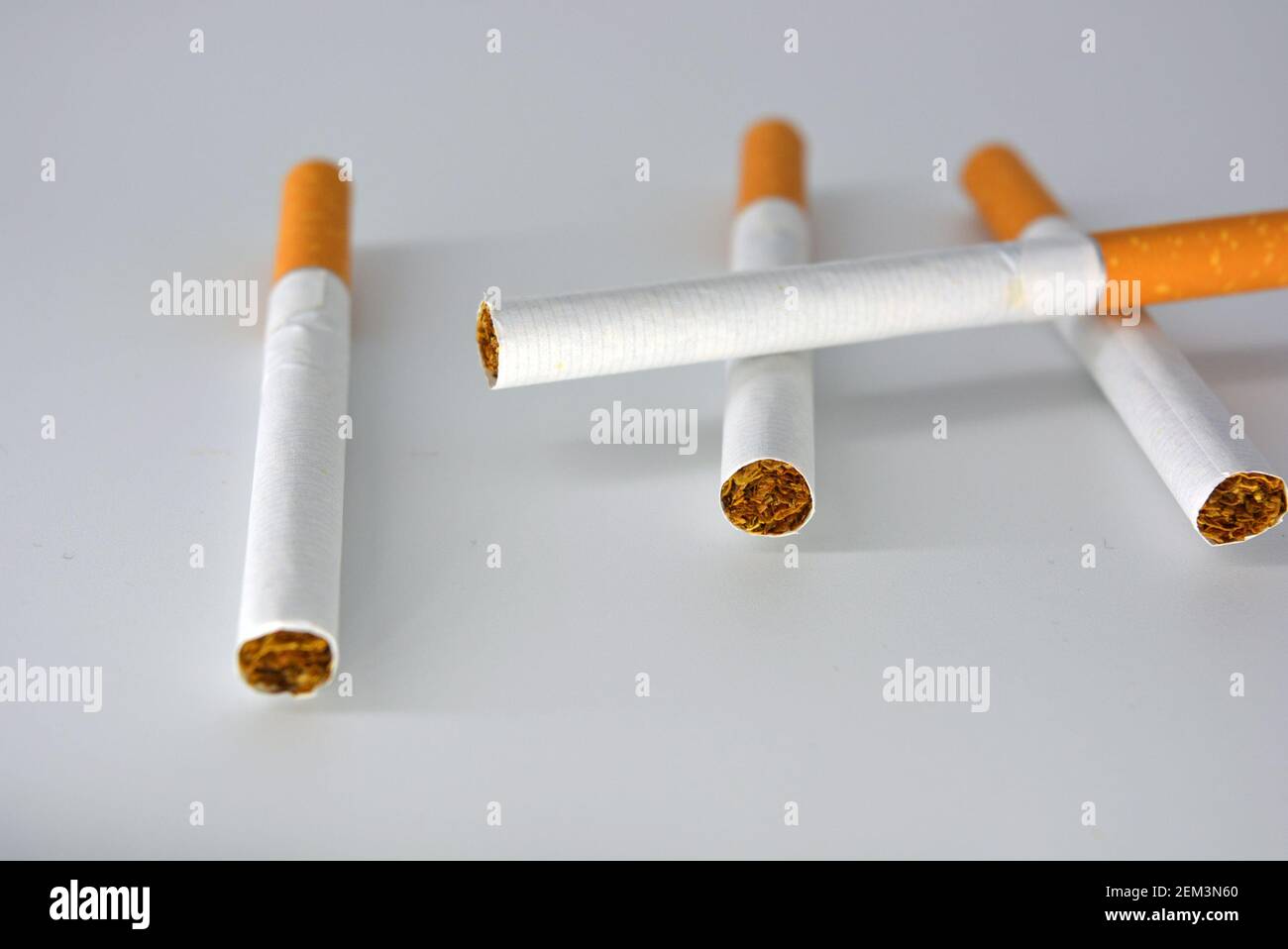 Many white cigarettes with a brown filter chaotic arranged on a white  background. Smoking is blicking bad on health. Cigarettes worsen the work  Stock Photo - Alamy