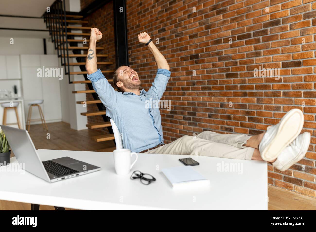 Man sitting with feet up on table hires stock photography and images