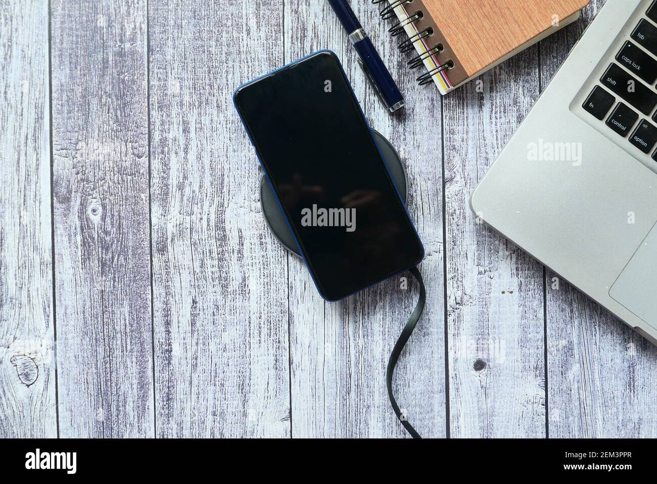 charging Smartphone using Wireless Charging Pad, top view Stock Photo