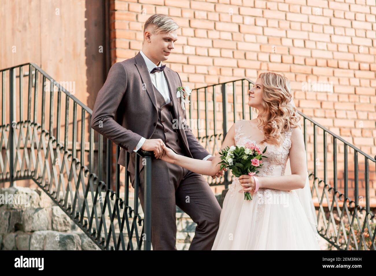 bride and groom standing on the porch of a brick house Stock Photo - Alamy