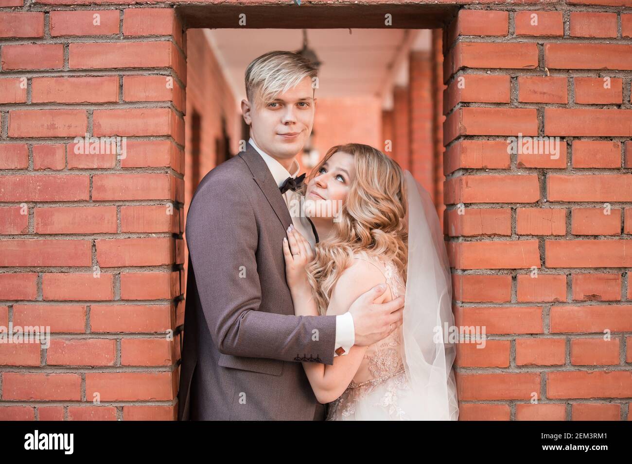 happy newlywed couple hugging each other while walking Stock Photo - Alamy