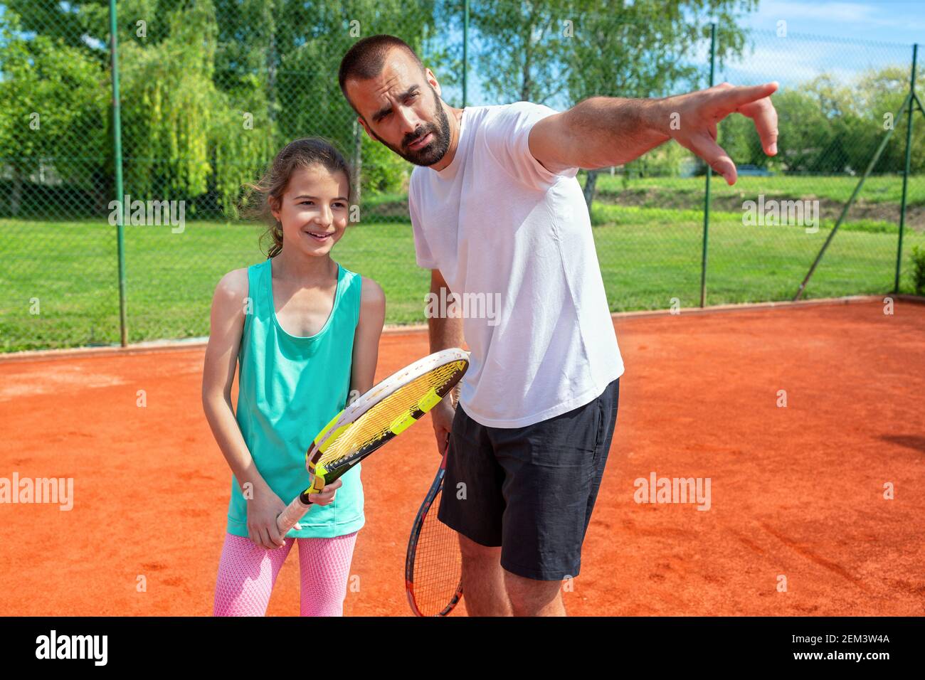 Tennis coach explaining to his student about some game details Stock