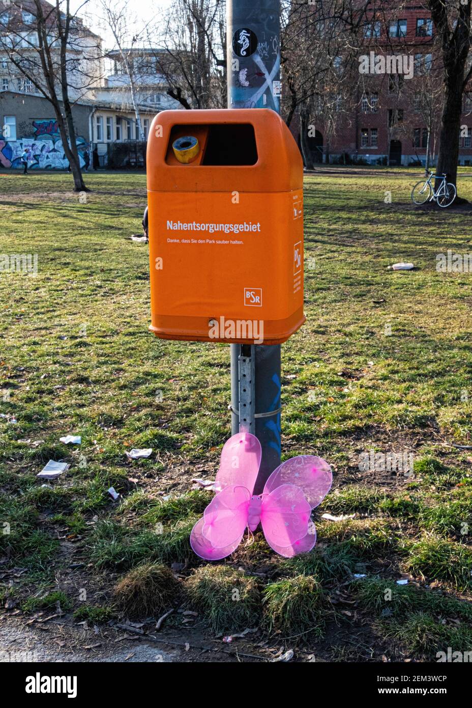 Abandoned or dumped pink butterfly next to an orange trash can in Mitte, Berlin,Germany Stock Photo - Alamy