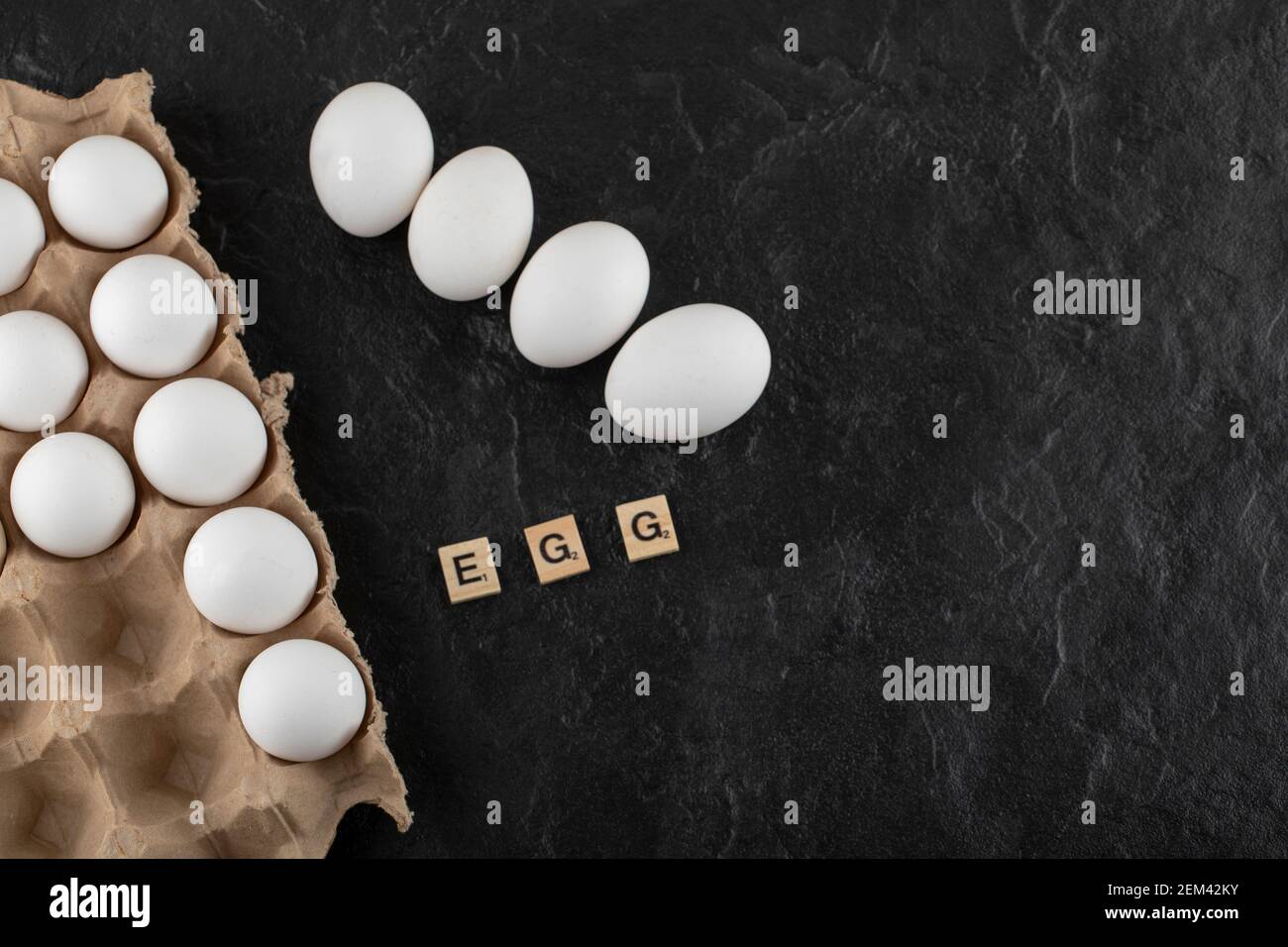 Cardboard egg box with white chicken eggs on a black background Stock ...