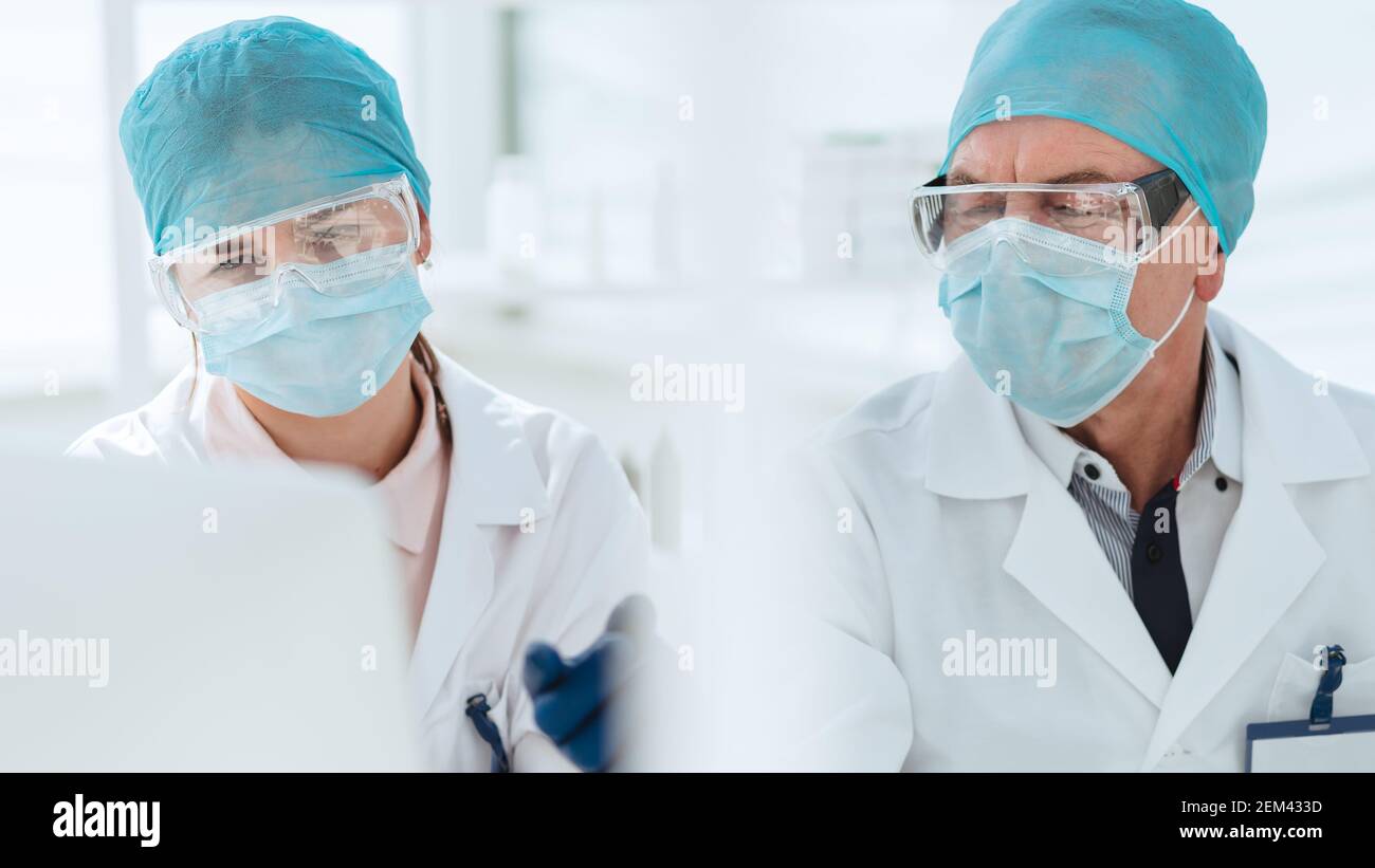 close up. scientists in laboratory masks looking at a computer monitor ...