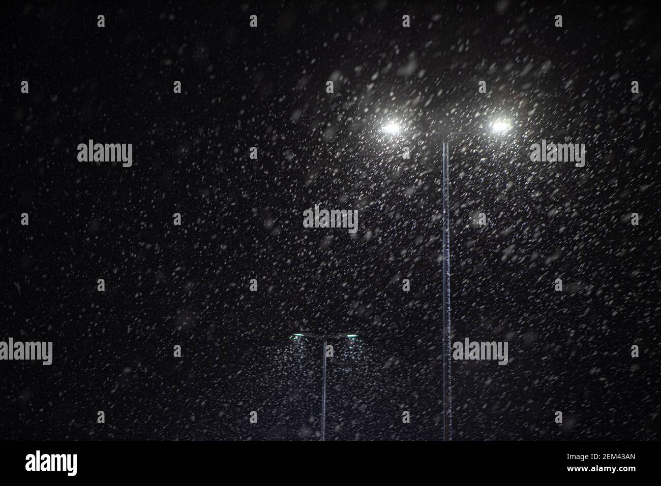 Snow falling at night on the background of a burning street lamp Stock ...