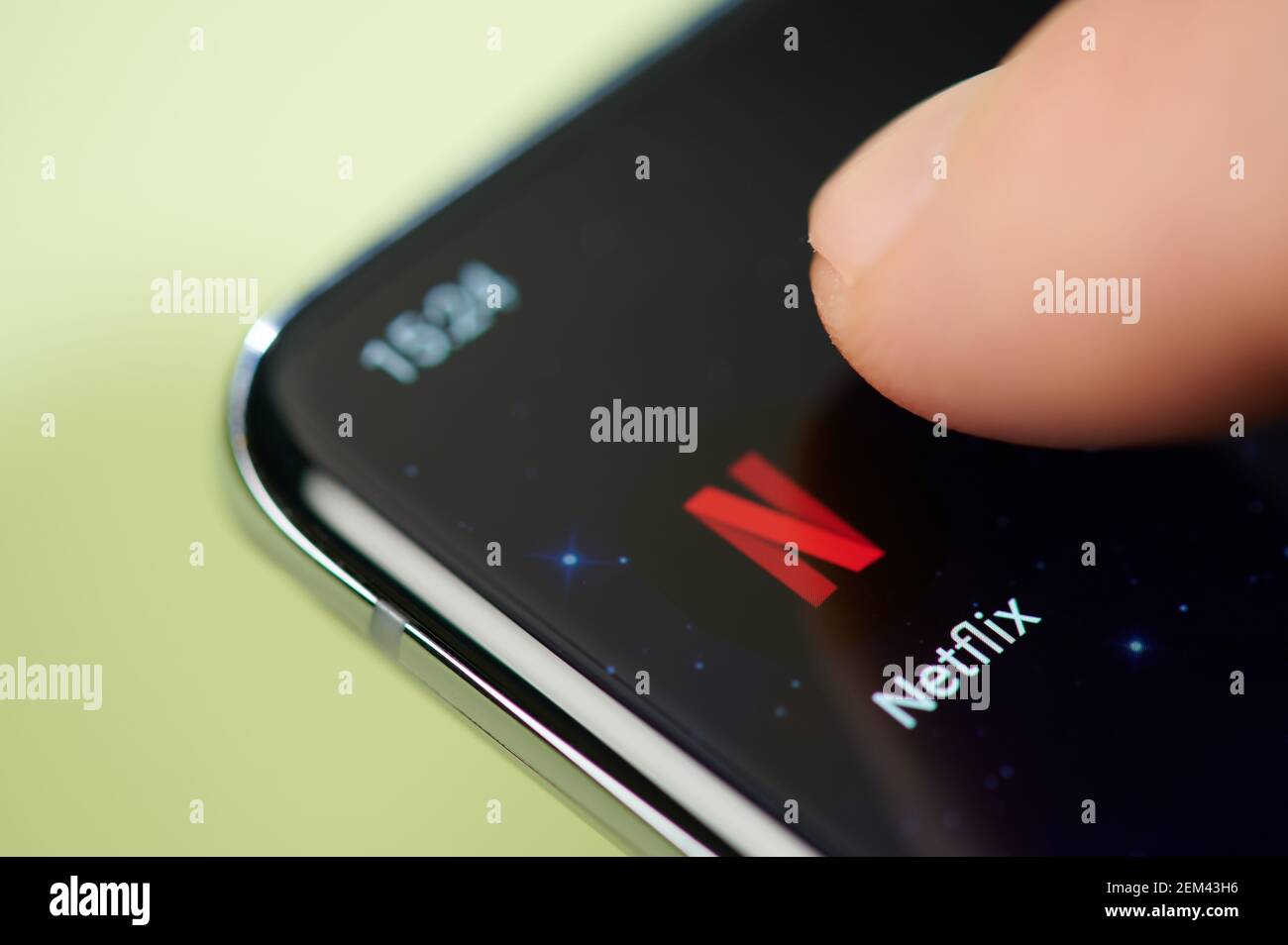 New york, USA - February 24, 2021: Netflix app on smartphone screen touch with finger macro close up view Stock Photo