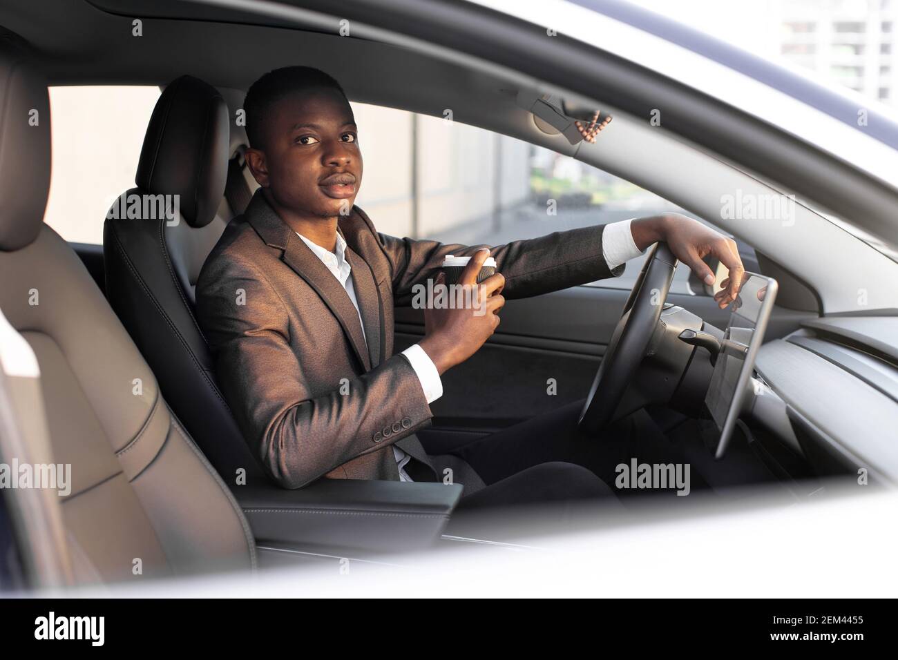 Handsome young dark skinned man in formal wear sitting in his modern ...