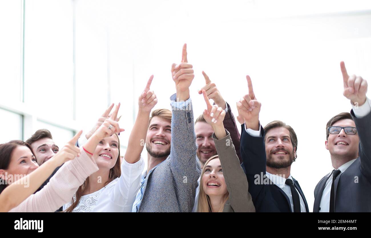 group of confident young people, pointing somewhere up. Stock Photo