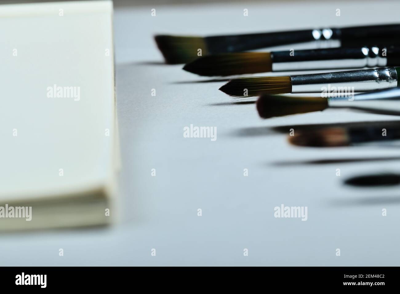 Paintbrushes and empty notebook on white background Stock Photo
