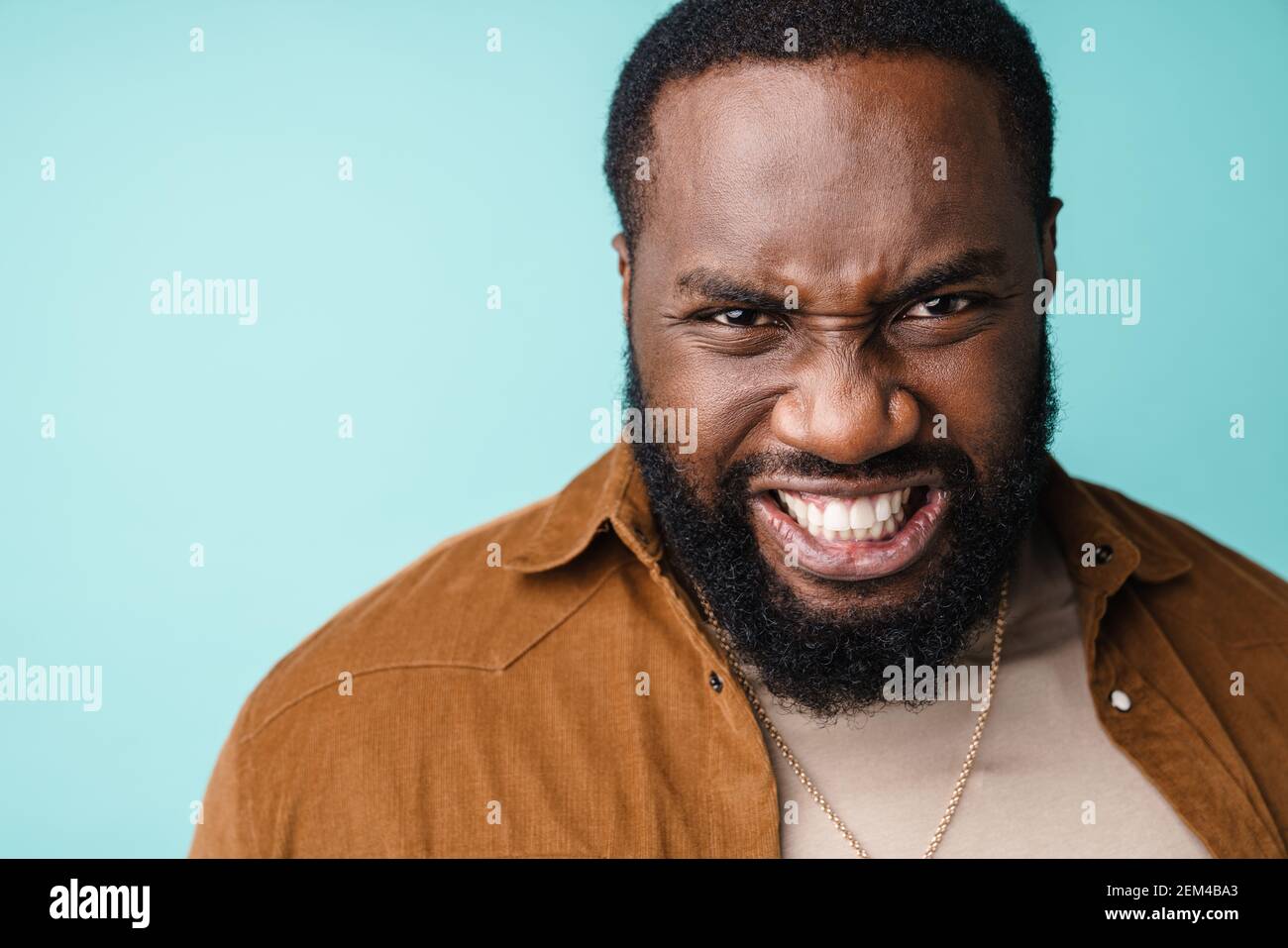 Angry upset african man standing isolated over blue background, casual ...