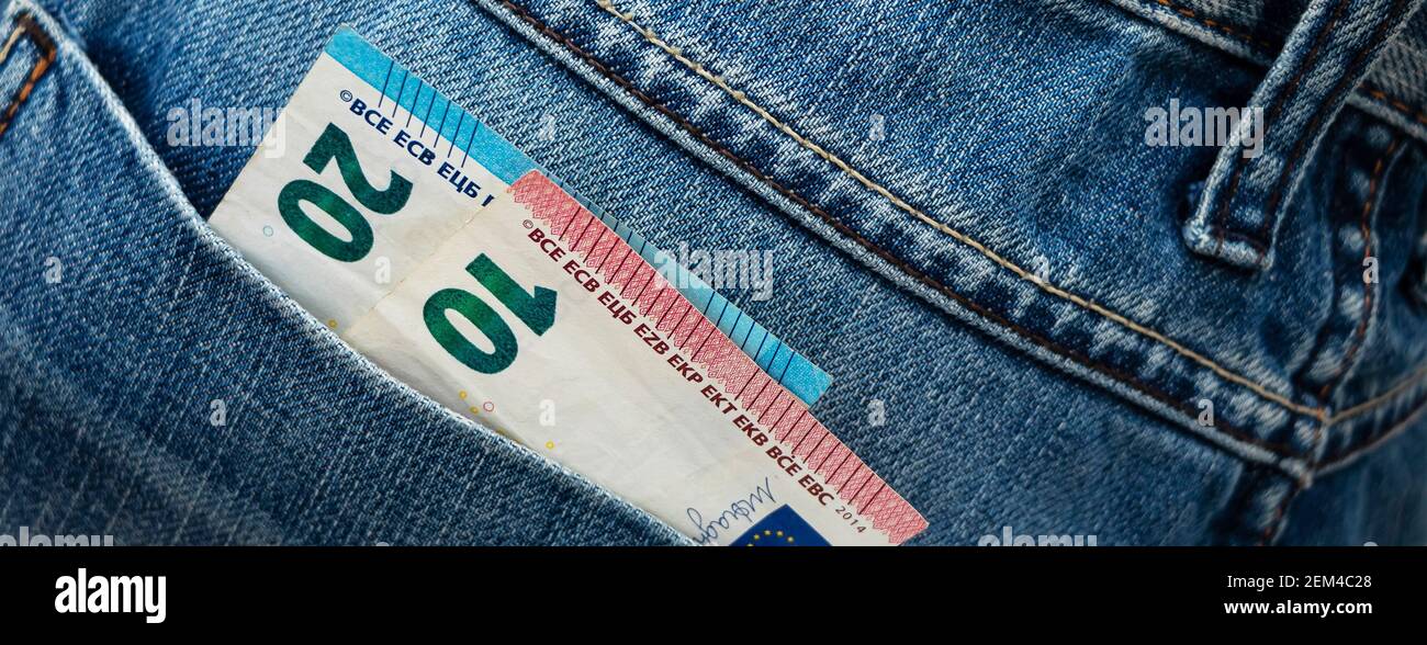Banner with euro bill in the back pocket of jeans. ThirtyEuro in a denim pocket. Close-up Stock Photo