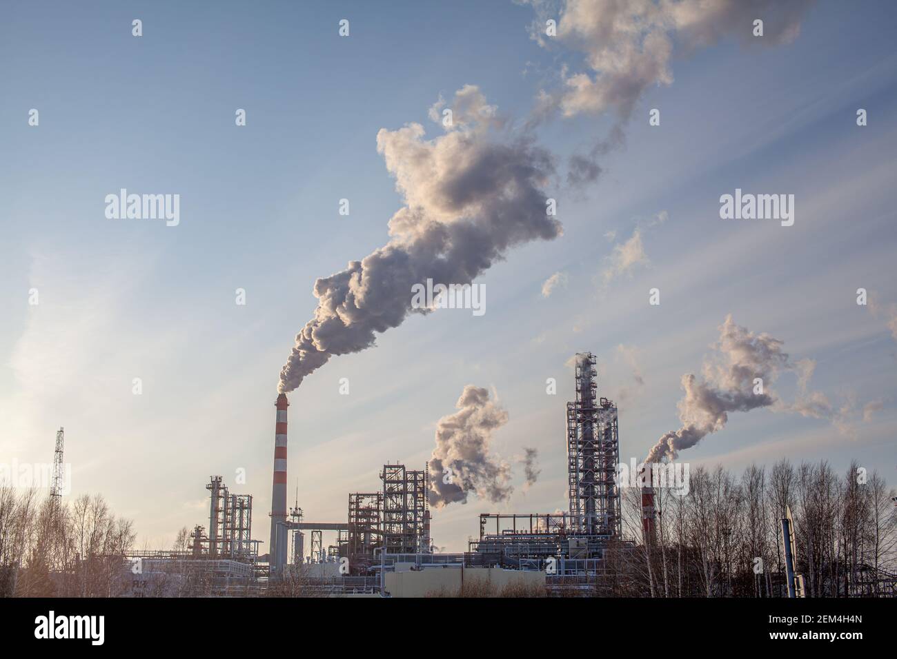Petrochemical industrial factory of heavy industry, power refinery production with smoke pollution. Thick smoke is coming from the factory's chimney Stock Photo