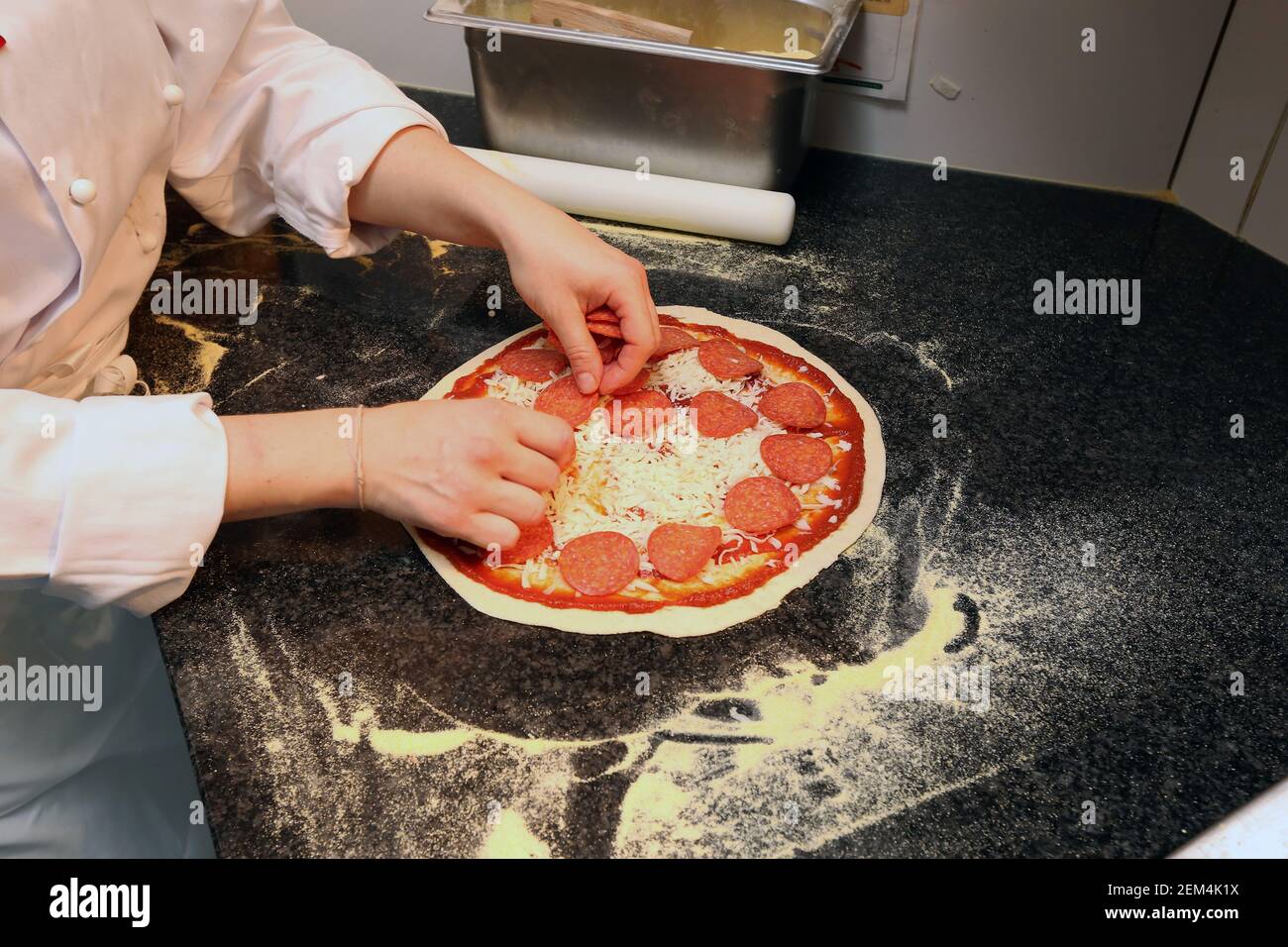 A pepperoni pizza being prepared in a restaurant Stock Photo