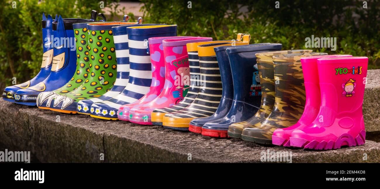 A line of colourful wellington boots of various sizes Stock Photo
