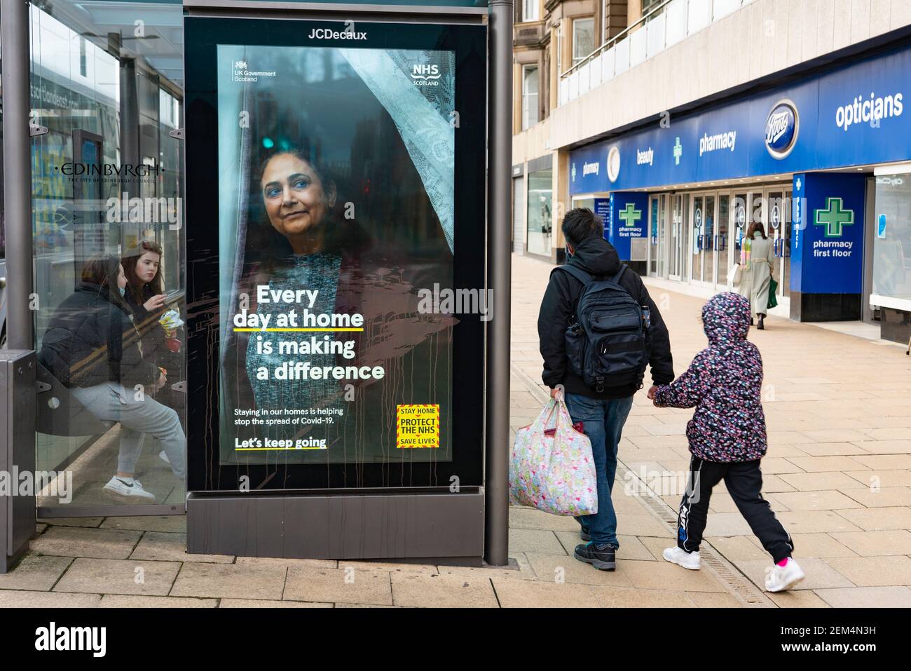 Edinburgh, Scotland, UK. 24 Feb 2021. As the UK and Scottish Governments outline rough timelines to ease the current lockdown , retailers and businesses remain close in UK city centres. Normally busy Princes Street remains eerily deserted with virtually all shops closed. Pic; New advertising campaign by Government to ask public to stay at home. Iain Masterton/Alamy Live News Stock Photo