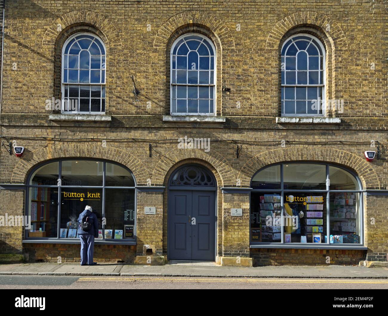 Historic Building being used as a wool and sewing shop person looking in window. Stock Photo