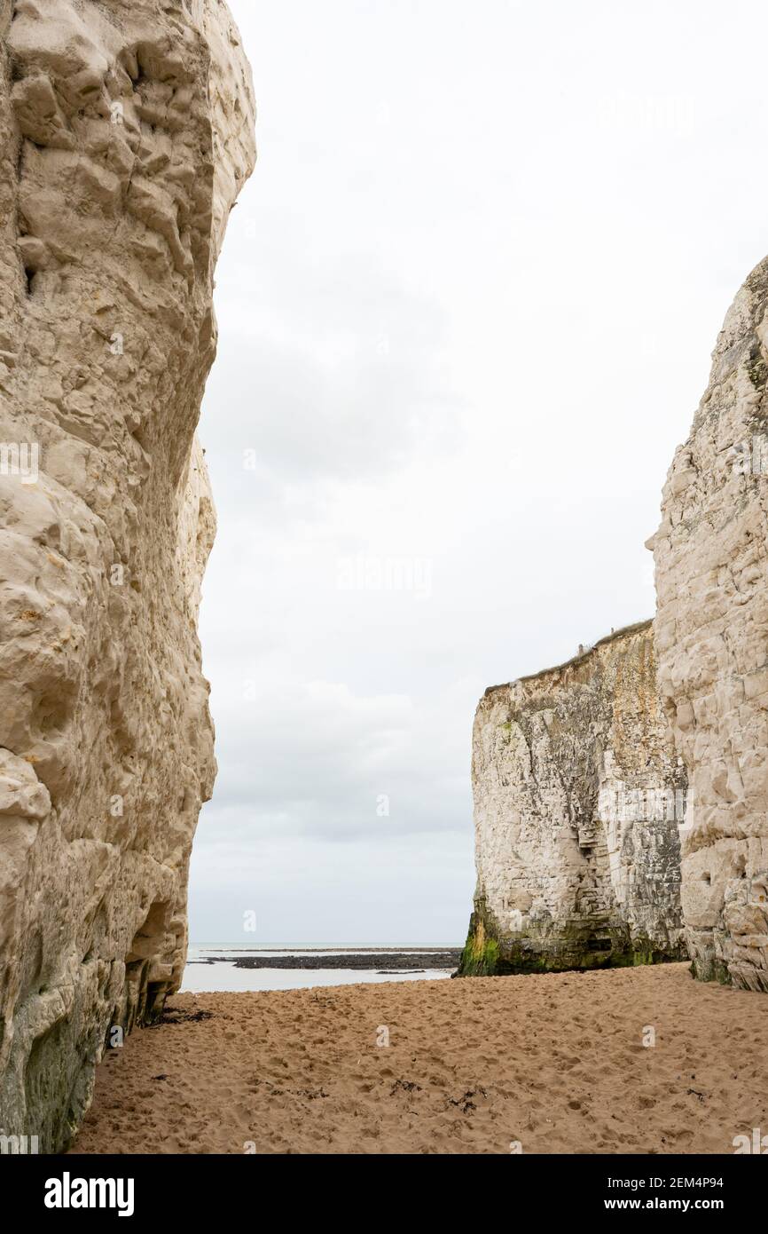 Portrait photograph of sandy beach in between chalk cliffs at botany bay, broadstairs kent, England on cloudy day with space for copy Stock Photo