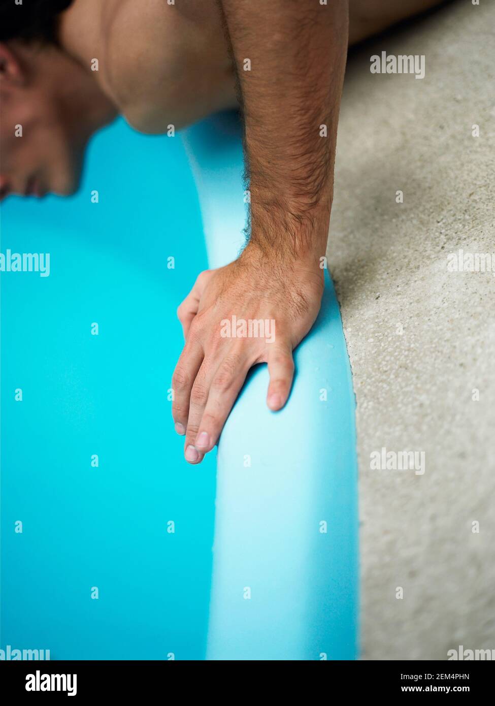 Close-up of a man lying at the poolside Stock Photo