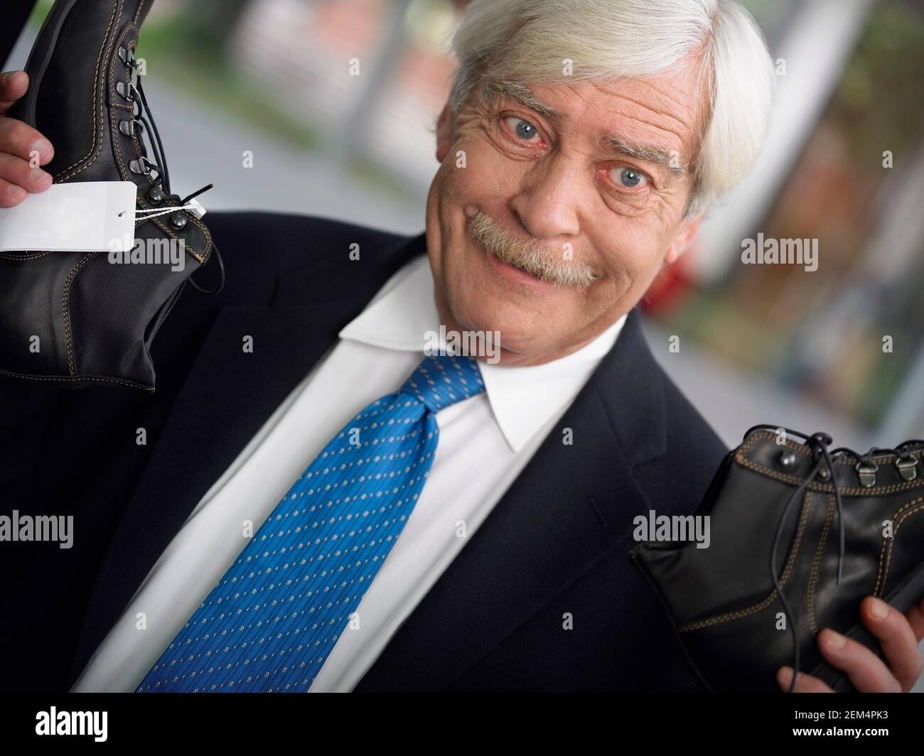 Close-up of a businessman holding a pair of shoes Stock Photo
