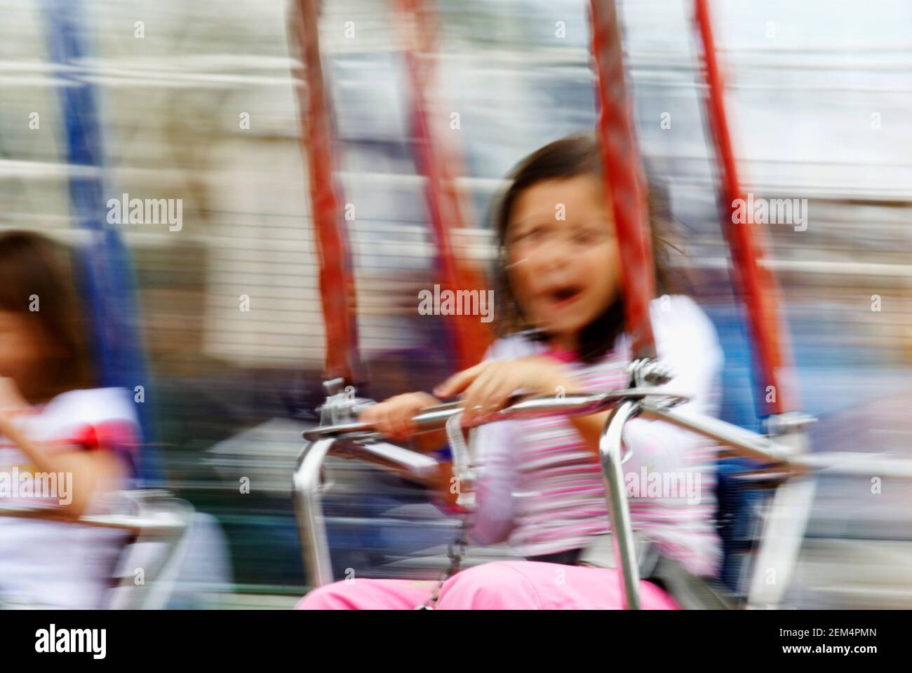 Two girls swinging on a chain swing Stock Photo