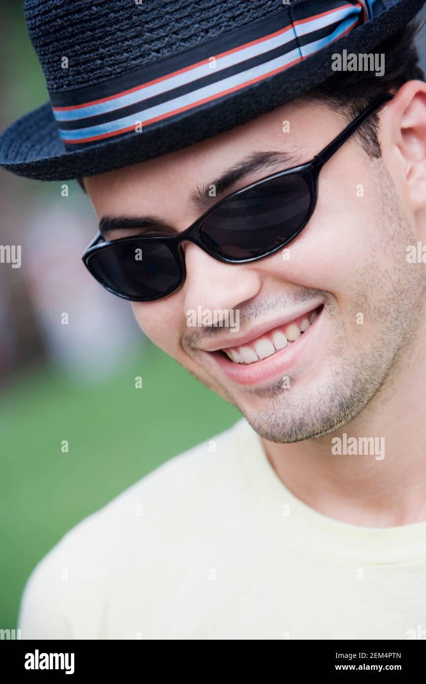 Portrait of a young man wearing sunglasses and smiling Stock Photo - Alamy