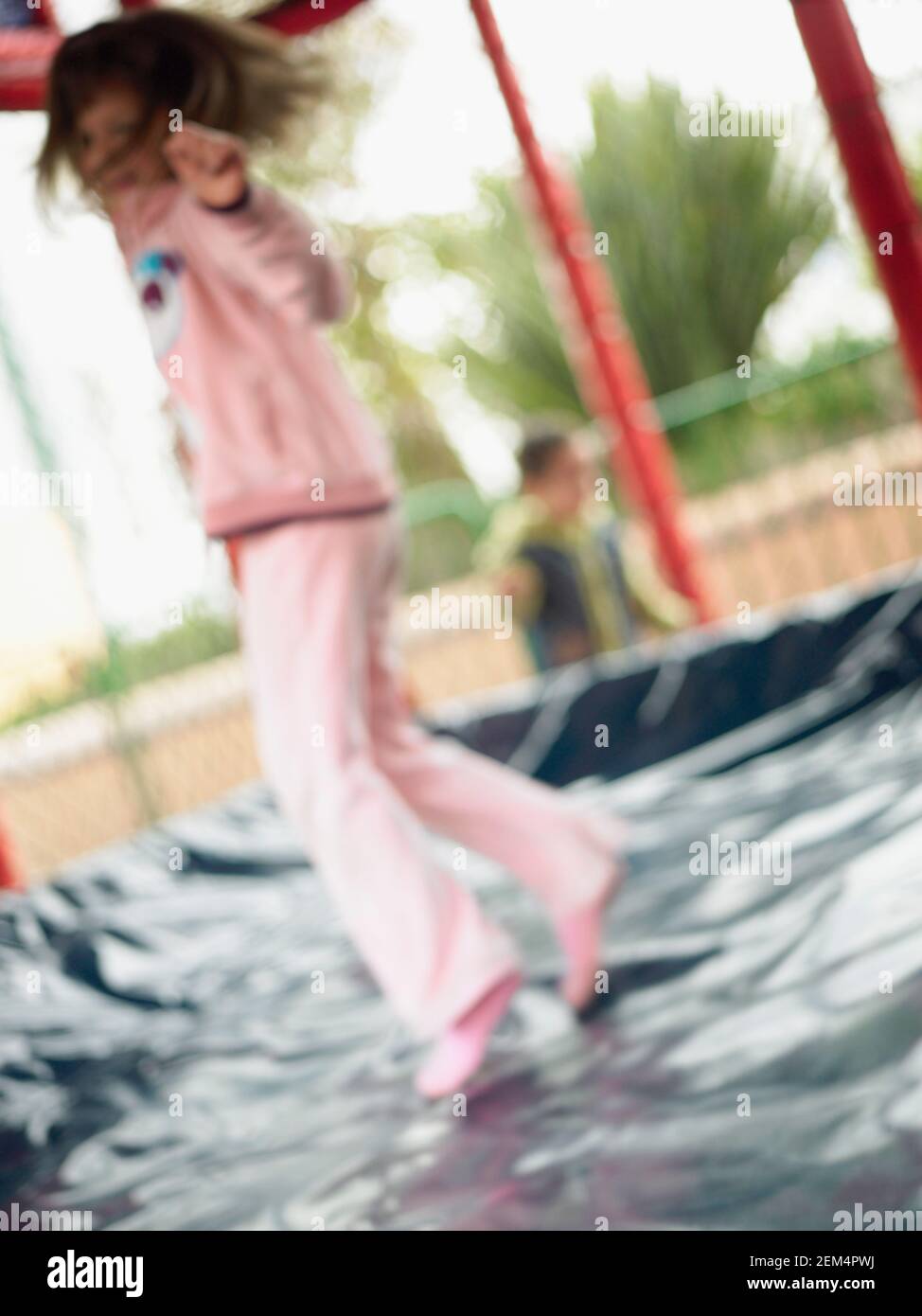 Side profile of a girl jumping on a trampoline Stock Photo