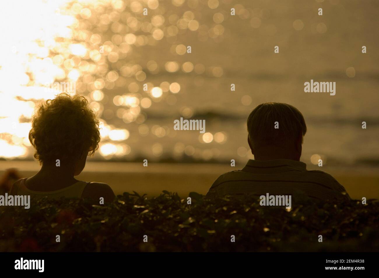 Silhouette of a man and a woman on the beach at dusk Stock Photo