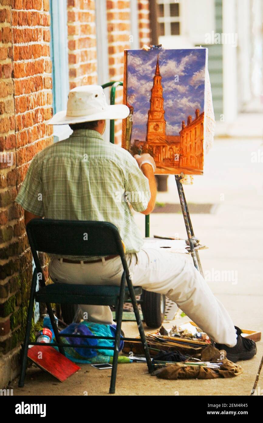 Rear view of a painter painting on canvas Stock Photo