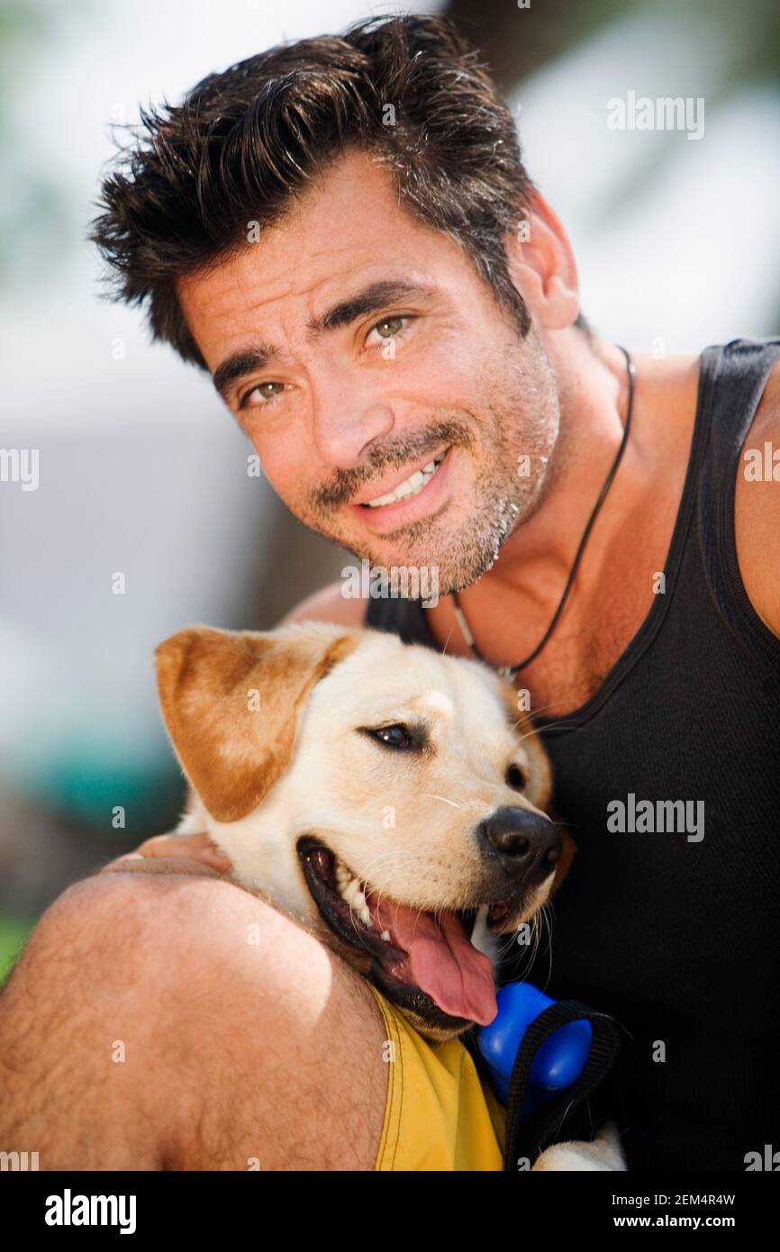 Portrait of a mid adult man smiling with a dog panting Stock Photo