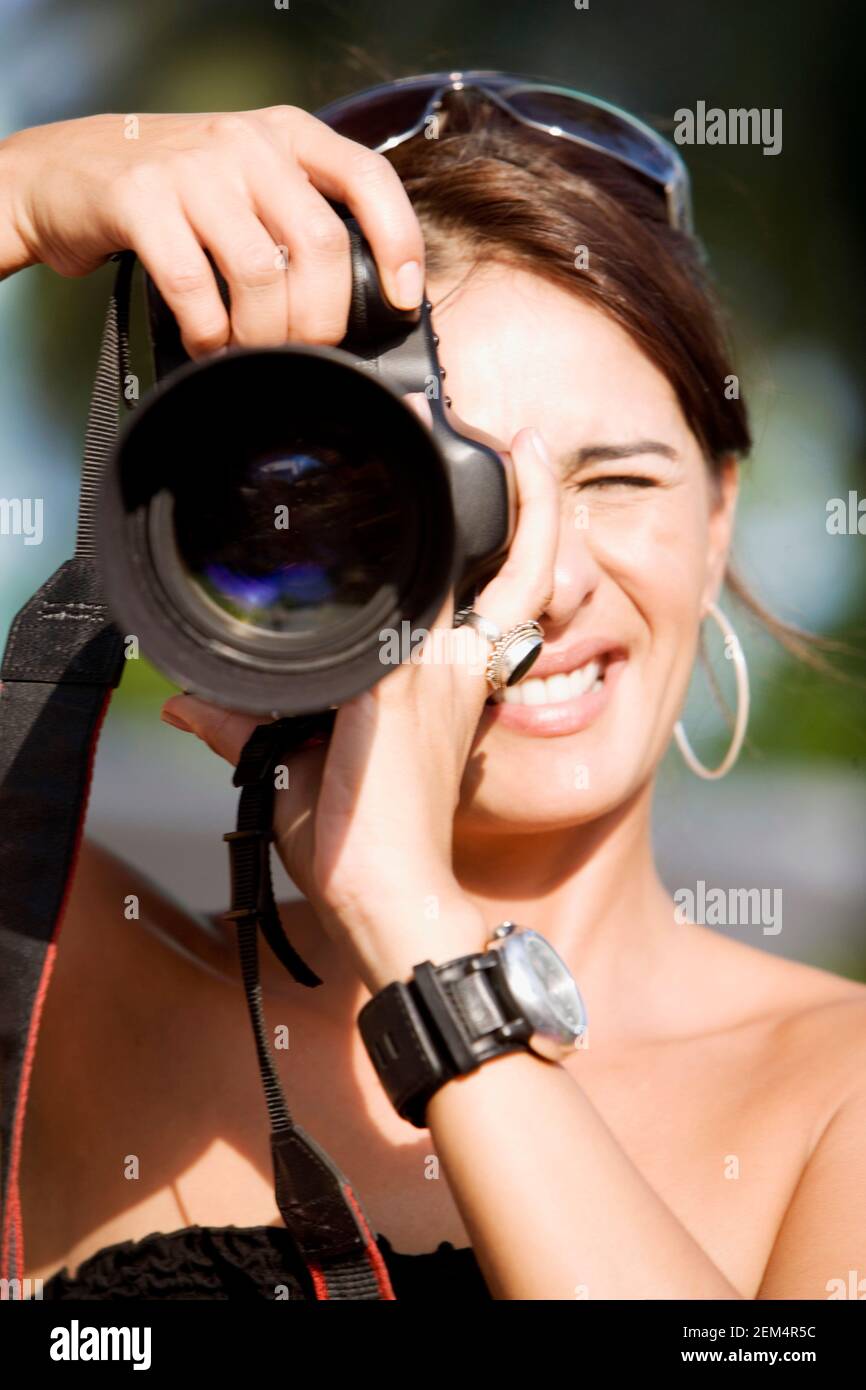 Close-up of a mid adult woman taking a photograph with a camera Stock Photo