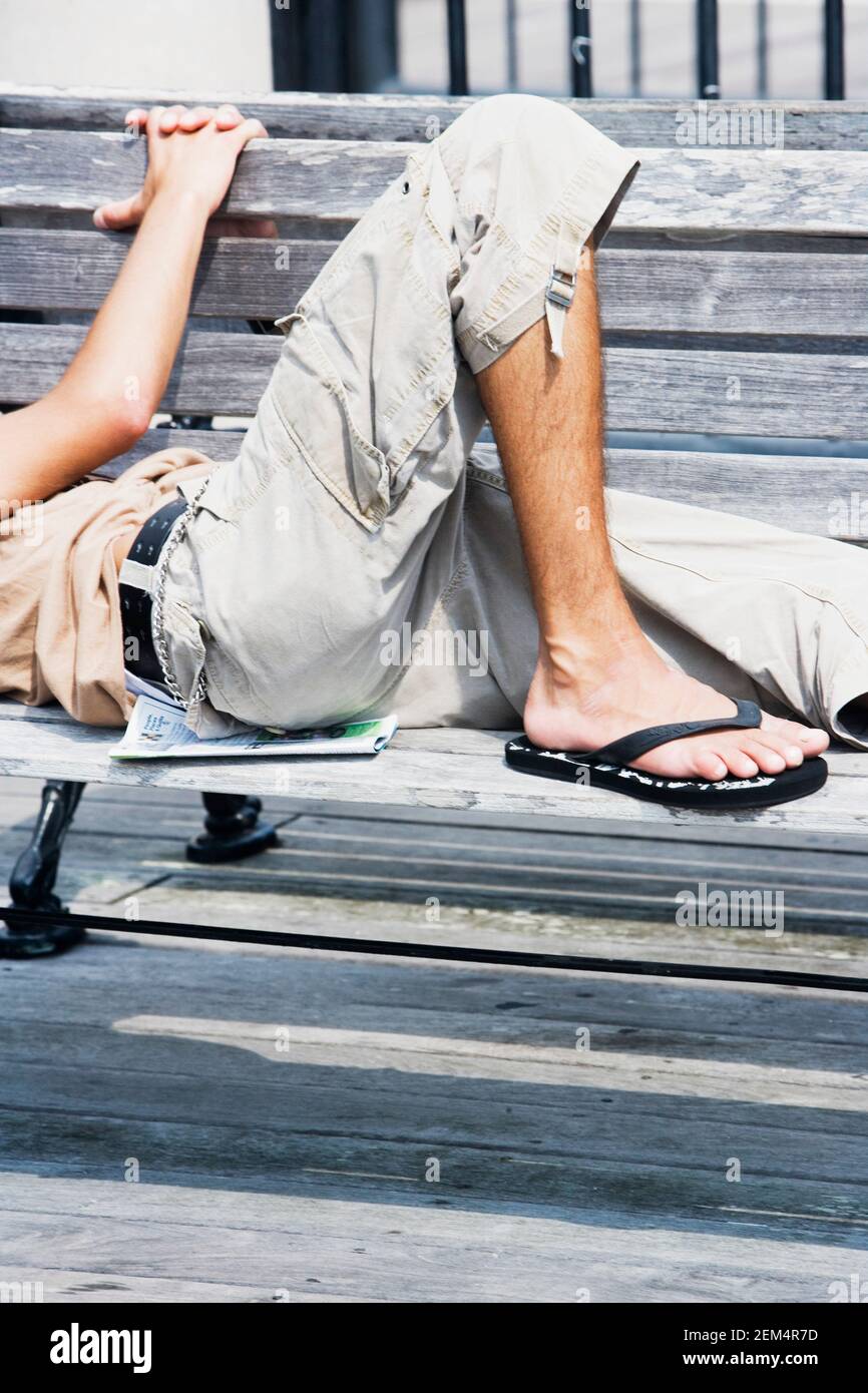 Side profile of a man lying on a bench Stock Photo