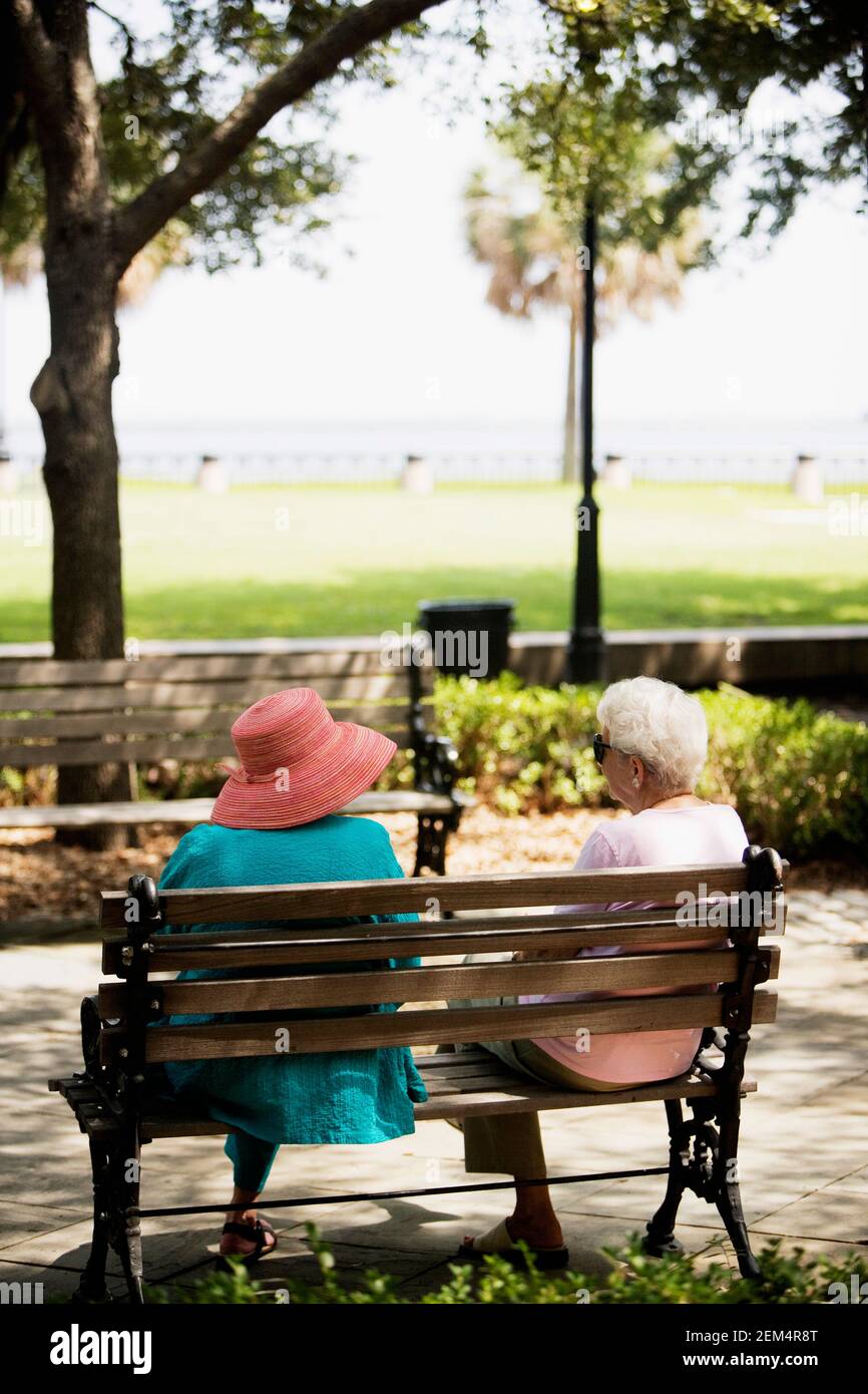 Rear view of two women sitting on a bench Stock Photo