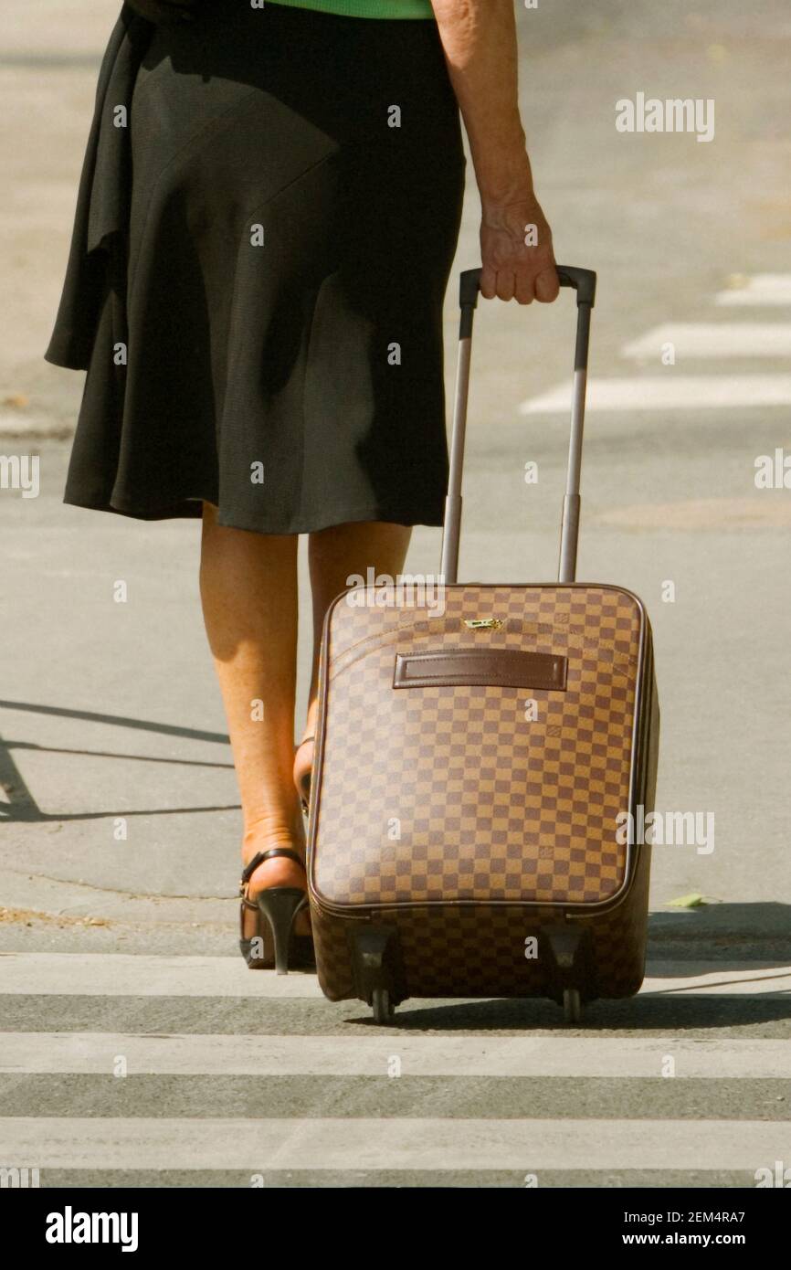 Low section view of a woman pulling a suitcase Stock Photo