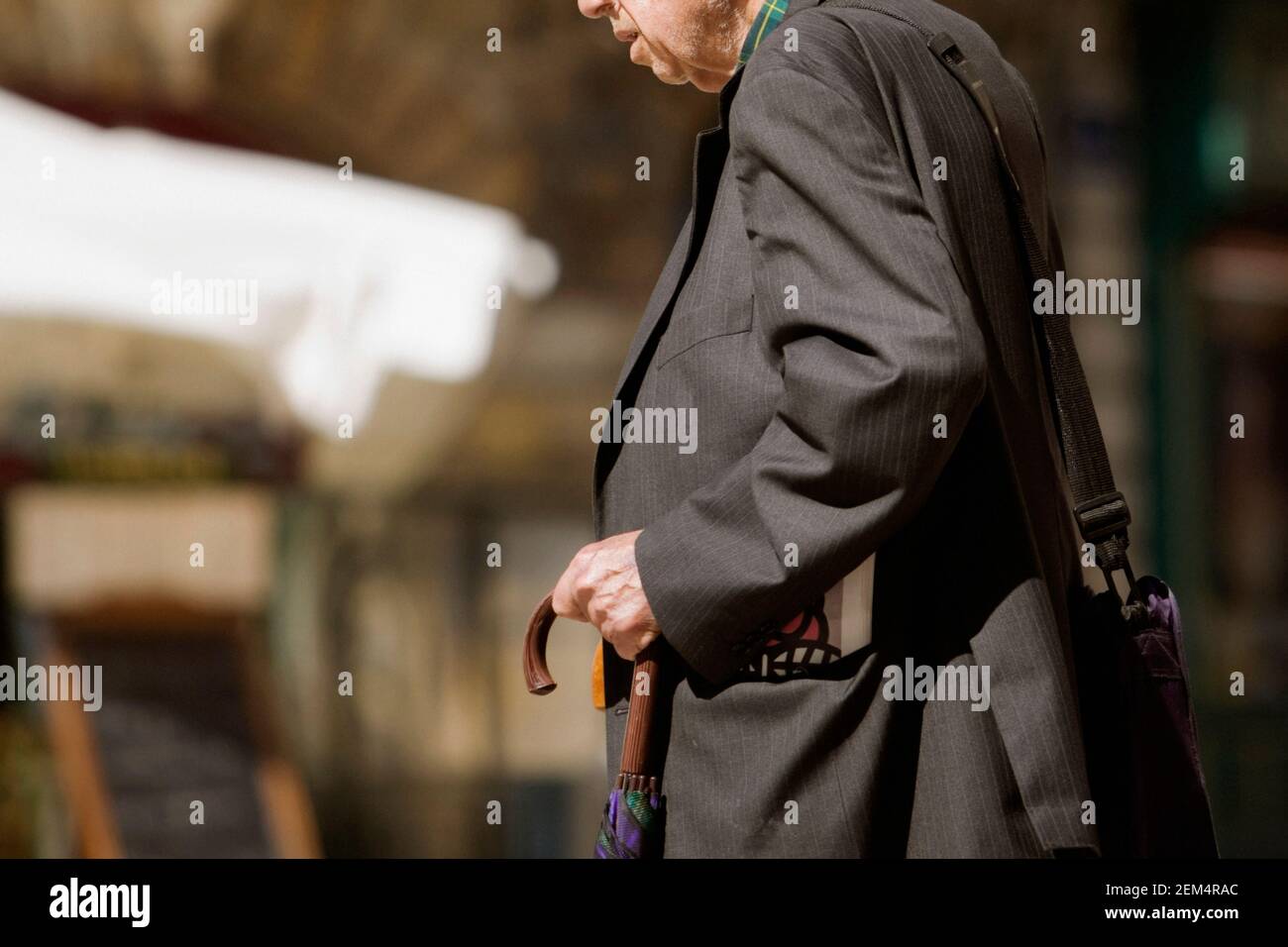 Side profile of a senior man holding an umbrella Stock Photo