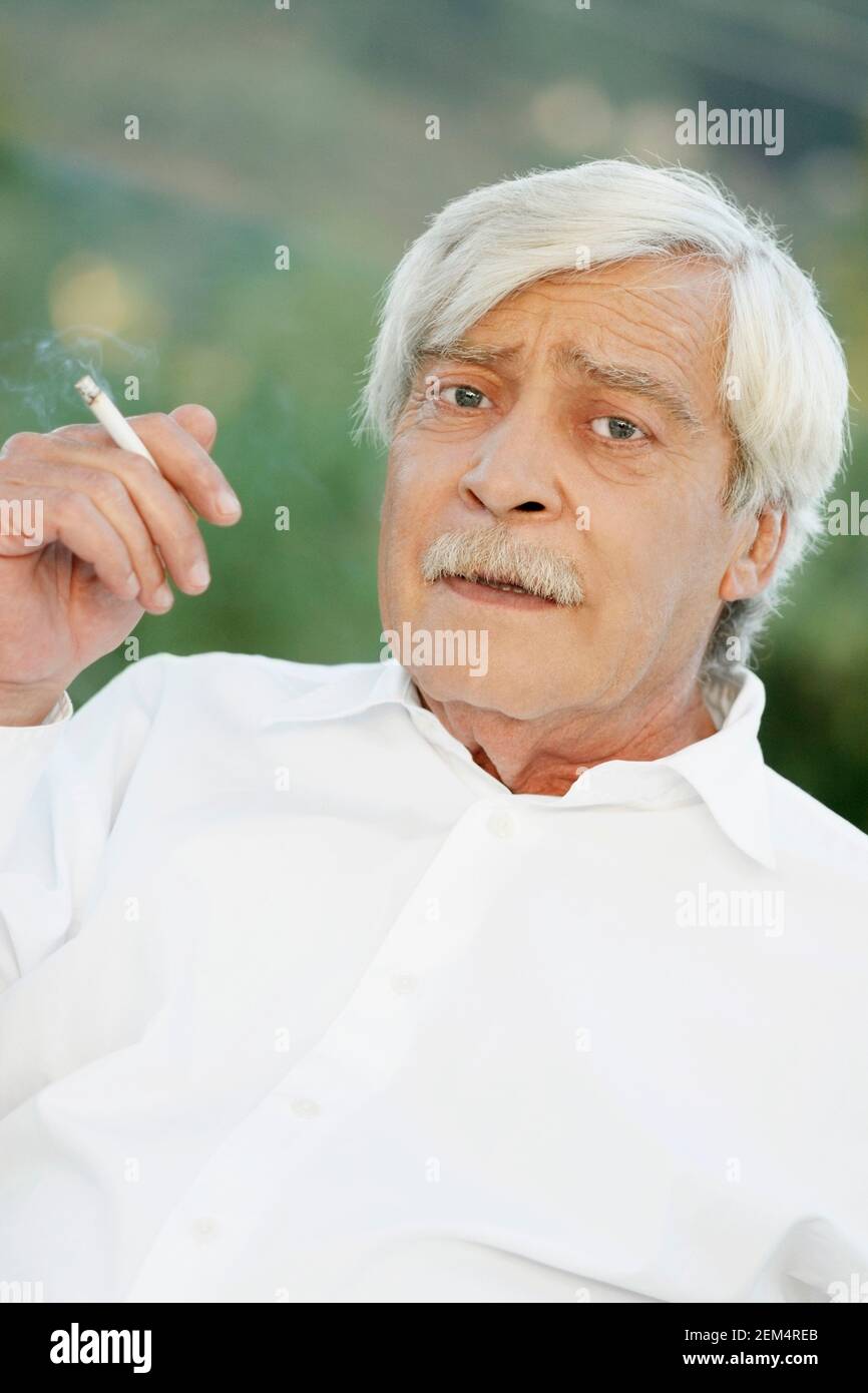 Portrait of a senior man smoking a cigarette Stock Photo