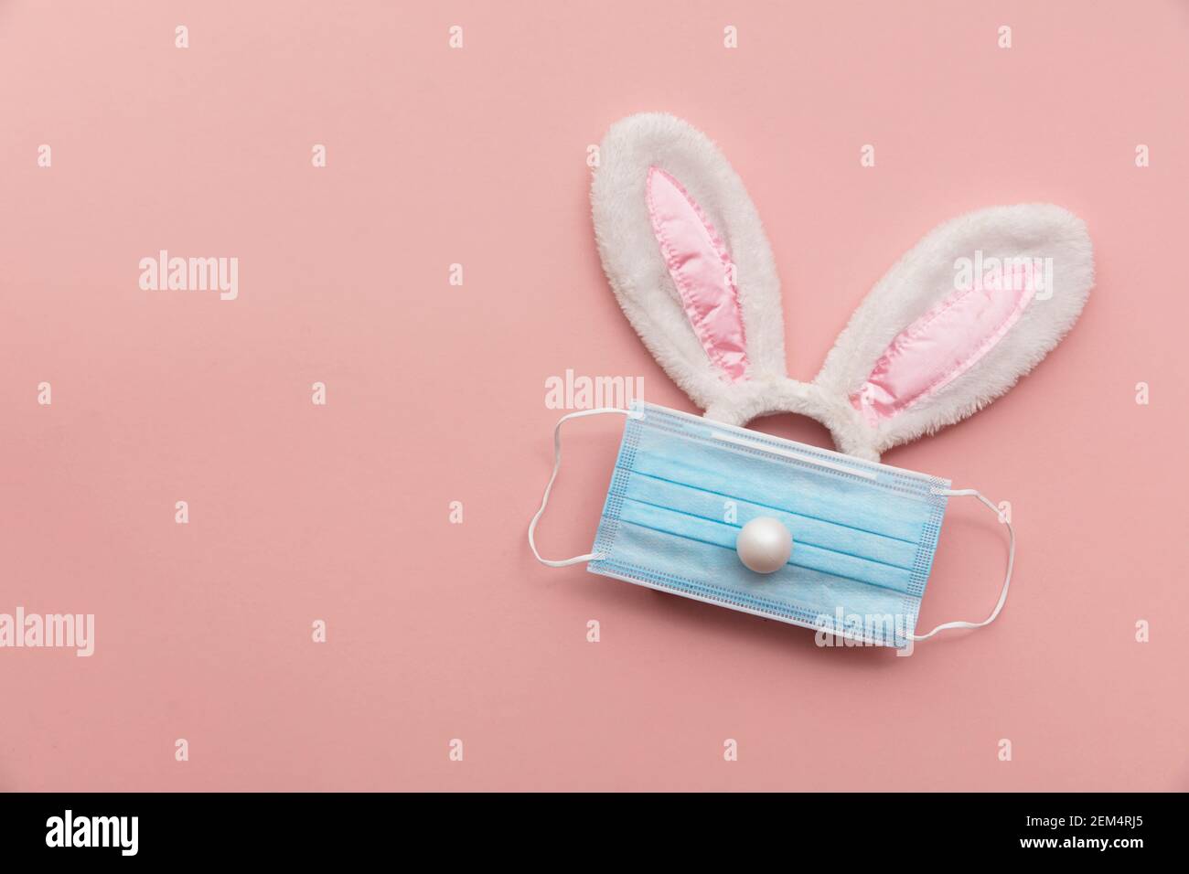 Coronavirus Easter bunny face made from rabbit ears and a protective face mask Stock Photo