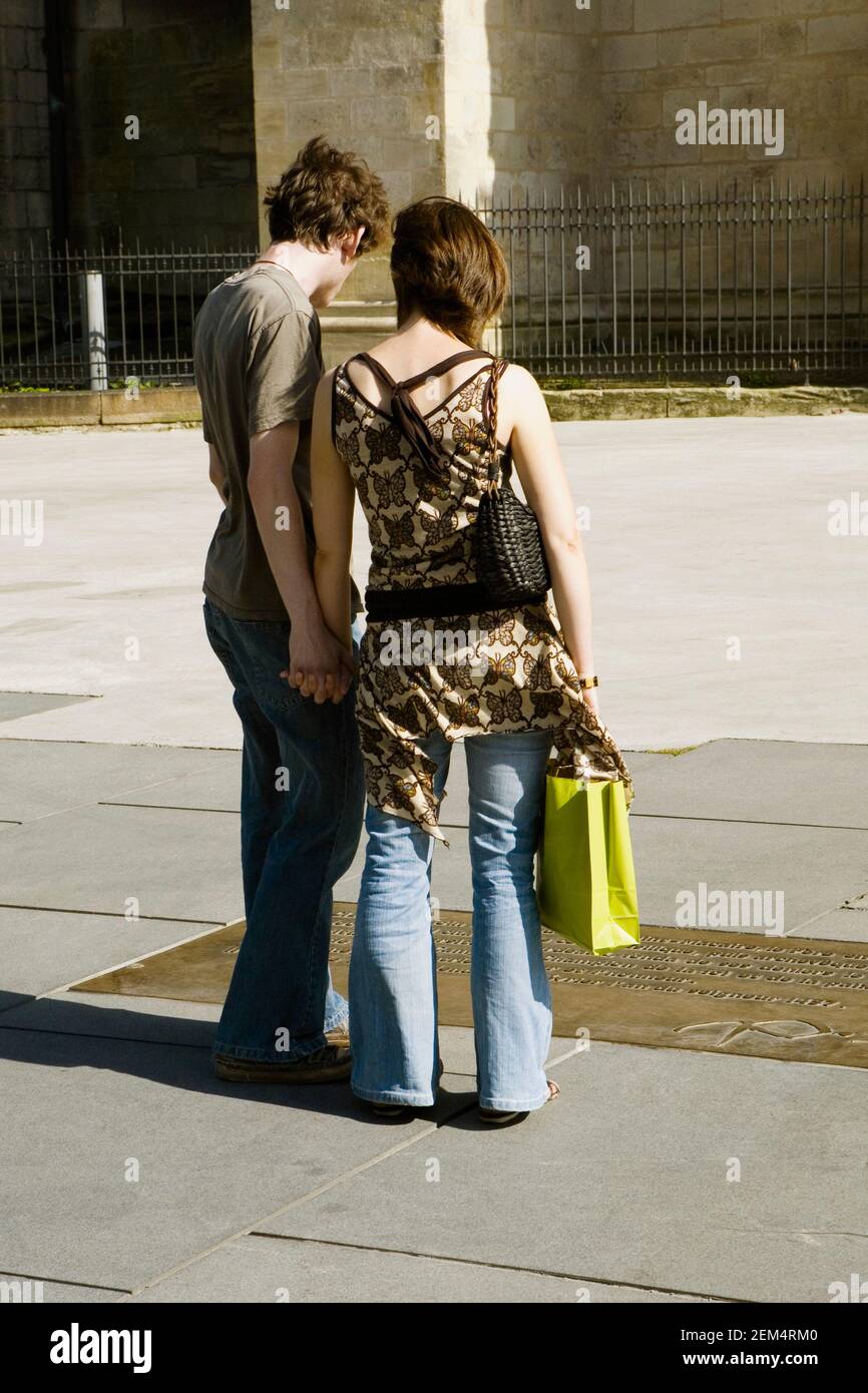 Rear view of a young couple standing and holding hands Stock Photo