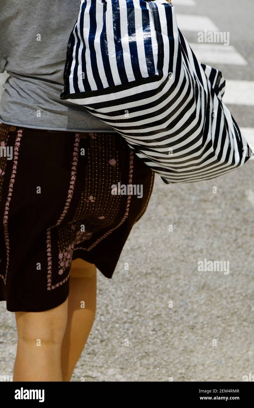 Woman walking holding skirt hi-res stock photography and images - Alamy
