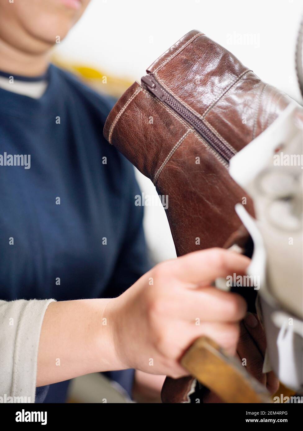 Mid section view of a mid adult woman working in a shoe factory Stock Photo