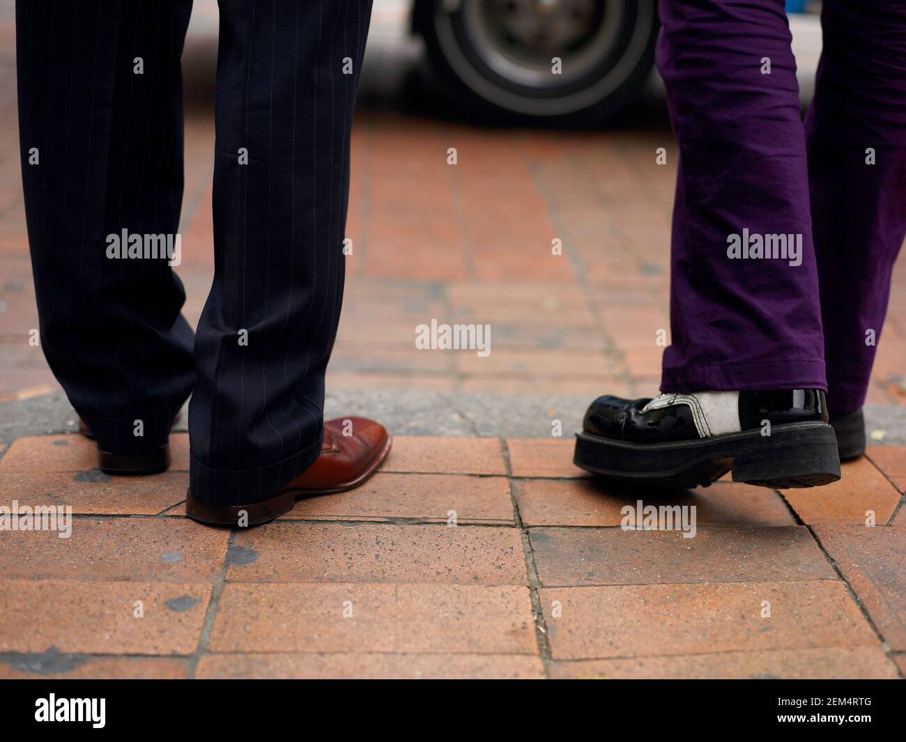 Low section view of two people walking on the street Stock Photo