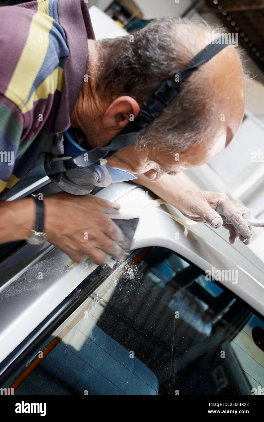 Close-up of a male mechanic working on a car in a workshop Stock Photo